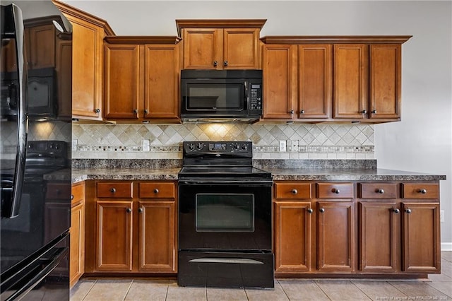 kitchen with black appliances, tasteful backsplash, brown cabinetry, and dark countertops