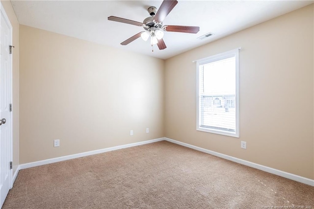 spare room featuring ceiling fan, carpet, visible vents, and baseboards