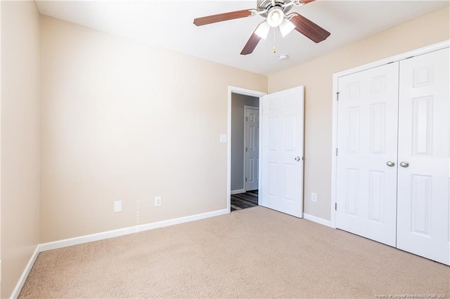 unfurnished bedroom with carpet floors, a ceiling fan, baseboards, and a closet