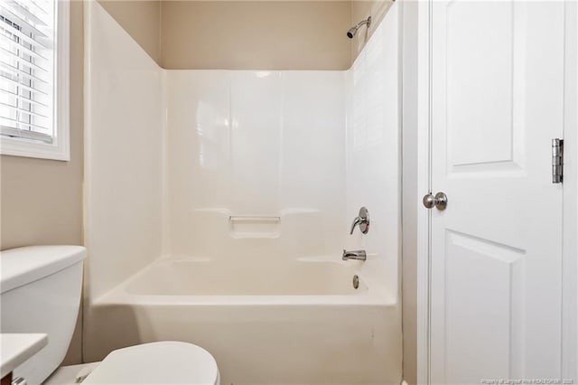 bathroom featuring bathing tub / shower combination and toilet