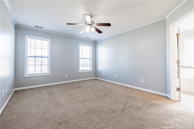 spare room featuring ceiling fan, carpet floors, visible vents, baseboards, and ornamental molding