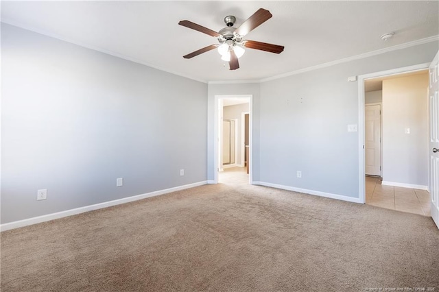 unfurnished room featuring light carpet, baseboards, a ceiling fan, and crown molding