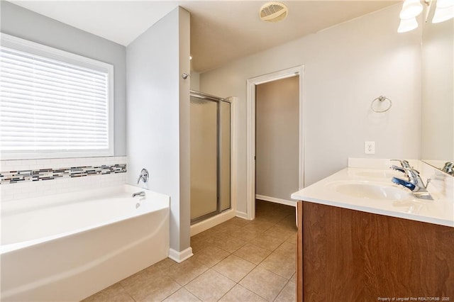 full bathroom featuring a stall shower, a sink, a bath, and tile patterned floors