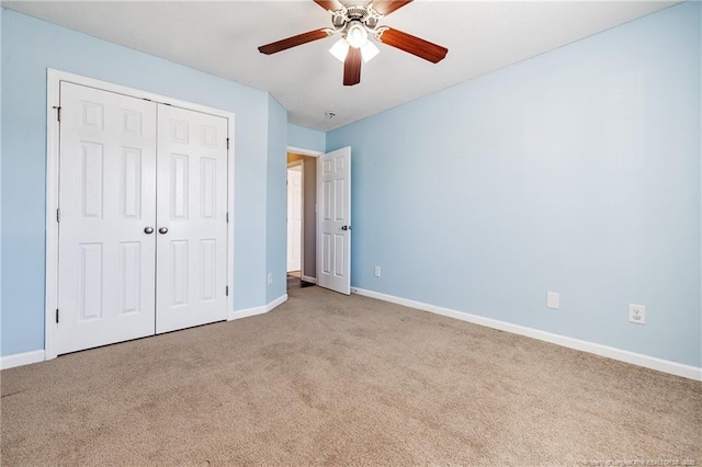 unfurnished bedroom with ceiling fan, a closet, baseboards, and carpet flooring