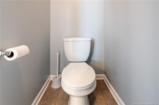 bathroom with toilet, baseboards, and tile patterned floors