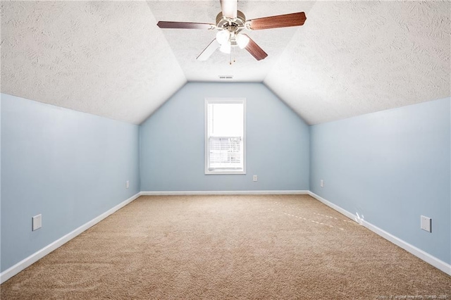 bonus room with baseboards, a ceiling fan, vaulted ceiling, a textured ceiling, and carpet flooring