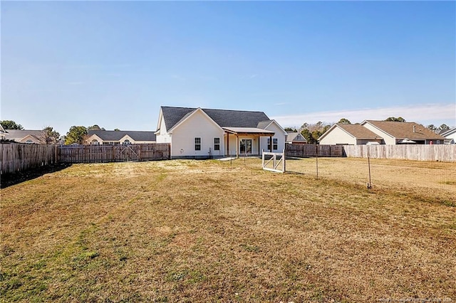 back of house featuring a fenced backyard and a yard