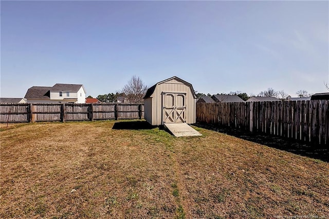 view of yard with an outbuilding, a fenced backyard, and a storage shed