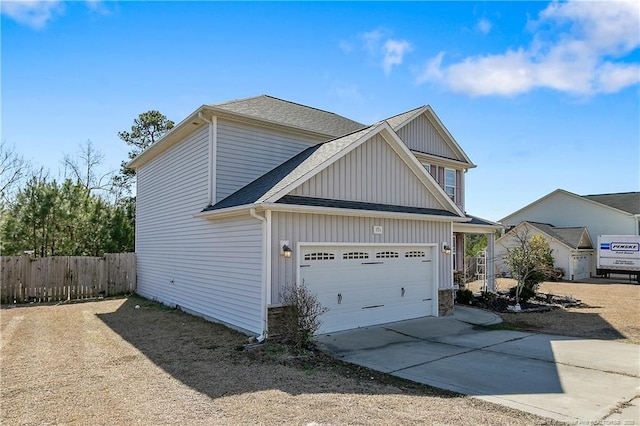 view of side of property featuring a shingled roof, an attached garage, board and batten siding, fence, and driveway