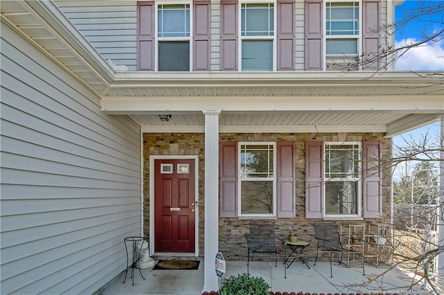 property entrance with stone siding and covered porch