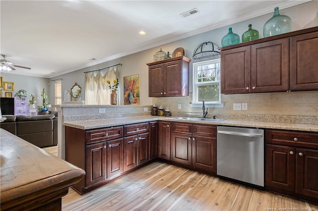 kitchen with visible vents, stainless steel dishwasher, a sink, light wood-type flooring, and a peninsula