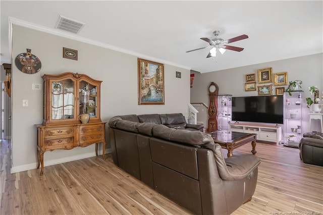 living area with ceiling fan, visible vents, baseboards, light wood finished floors, and crown molding