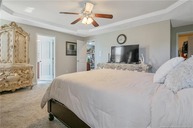 bedroom featuring a tray ceiling, ornamental molding, a ceiling fan, and light colored carpet