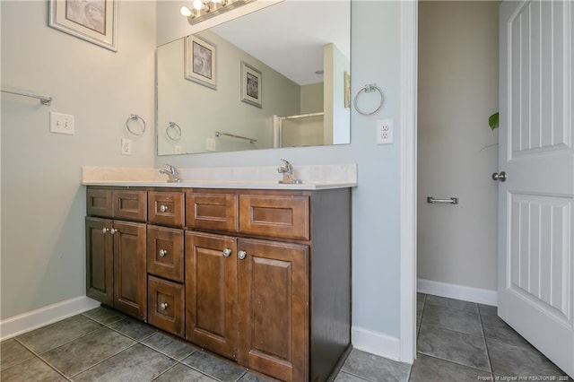 bathroom featuring double vanity, tile patterned flooring, baseboards, and a sink