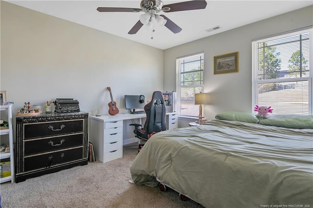 bedroom with a ceiling fan, visible vents, and light carpet