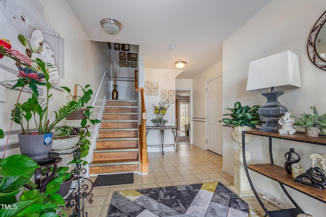 foyer featuring light floors and stairway