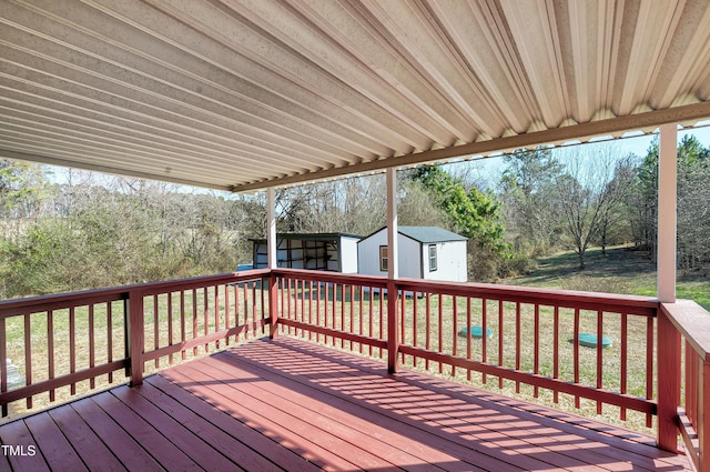 deck featuring a storage shed, a yard, and an outdoor structure