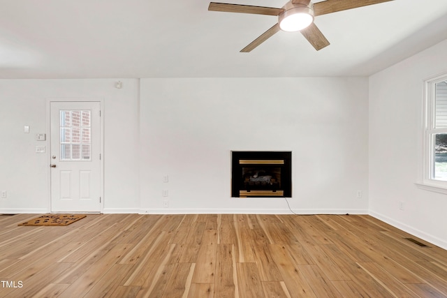 unfurnished living room featuring light wood finished floors, visible vents, and baseboards