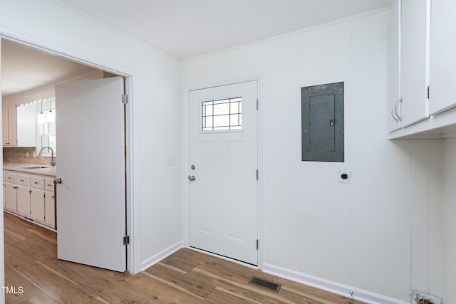 entrance foyer featuring light wood-style flooring, electric panel, visible vents, and baseboards