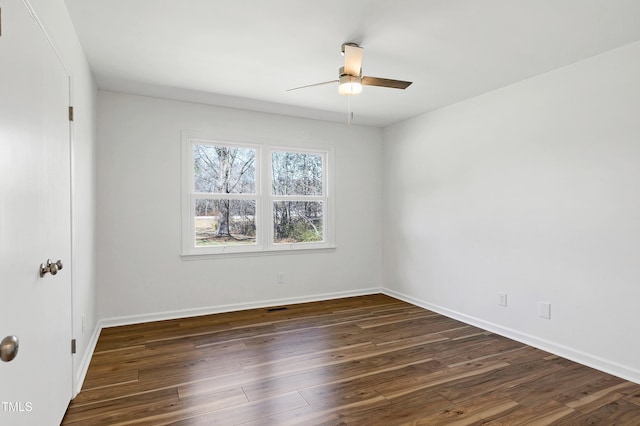 empty room featuring visible vents, dark wood-style flooring, a ceiling fan, and baseboards