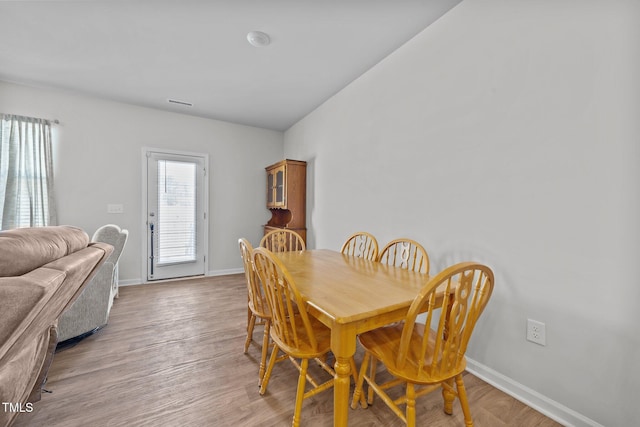 dining space featuring baseboards and light wood finished floors