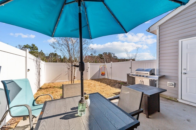 view of patio featuring a fenced backyard, a grill, and outdoor dining space