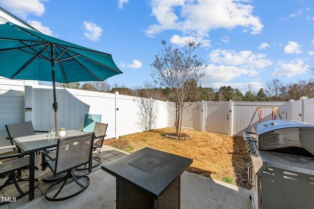 view of patio featuring outdoor dining space, a fenced backyard, and a gate