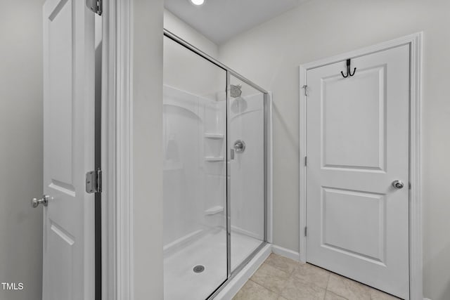 bathroom featuring a stall shower, baseboards, and tile patterned floors