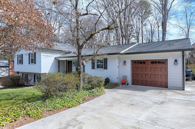 tri-level home featuring a garage and concrete driveway