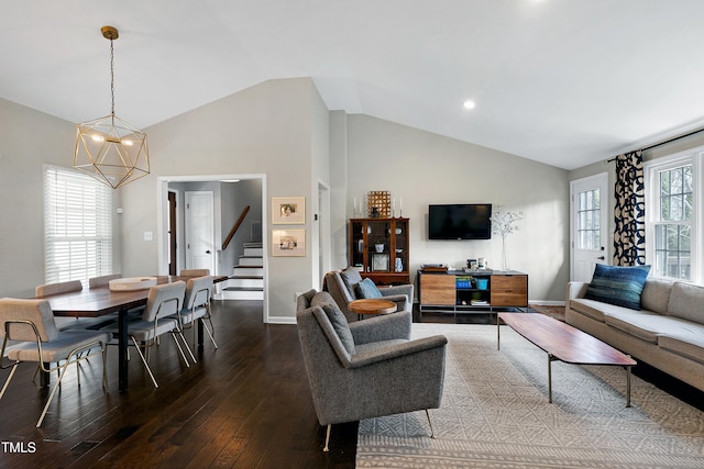 living area with hardwood / wood-style floors, baseboards, high vaulted ceiling, stairs, and a notable chandelier