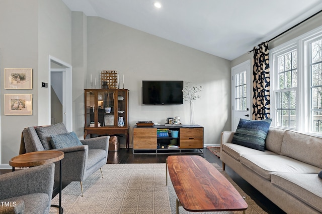 living room with high vaulted ceiling, baseboards, and wood finished floors