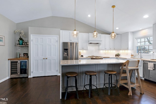 kitchen featuring dark wood-style floors, beverage cooler, white cabinets, appliances with stainless steel finishes, and a center island