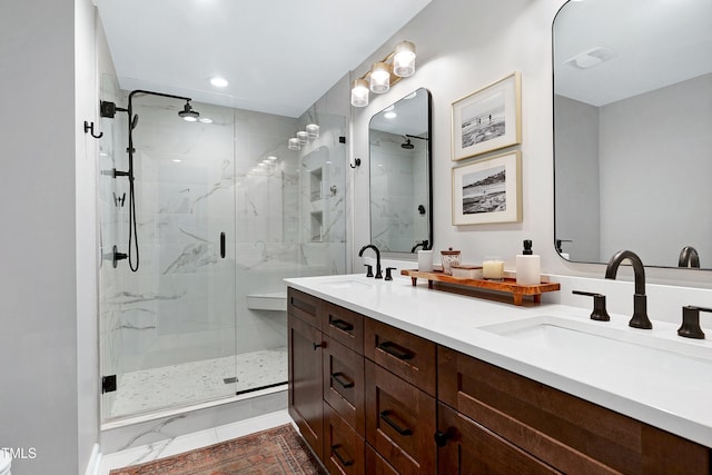 bathroom with double vanity, a stall shower, marble finish floor, and a sink