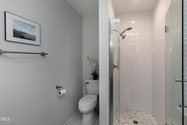 full bathroom with a shower stall, toilet, and baseboards