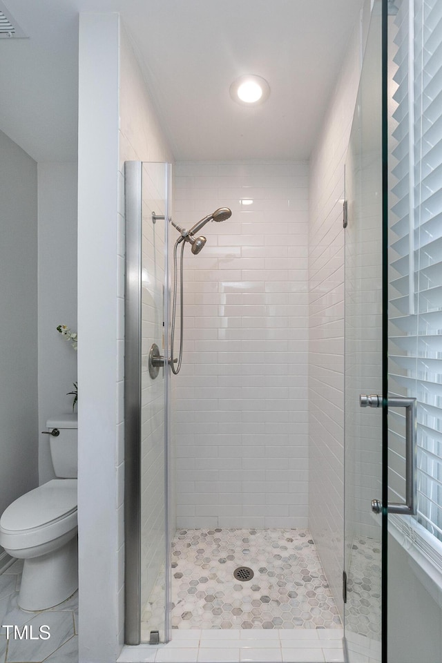 bathroom featuring visible vents, a stall shower, and toilet