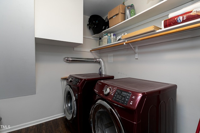 clothes washing area featuring baseboards, wood finished floors, laundry area, and washer and clothes dryer