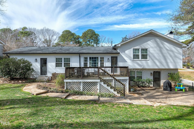 back of house with a yard, a wooden deck, and a patio area