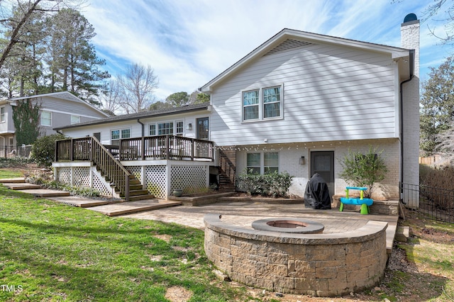 back of house with stairs, a fire pit, a wooden deck, brick siding, and a chimney