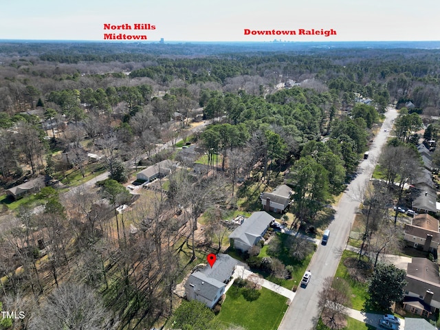 bird's eye view with a wooded view