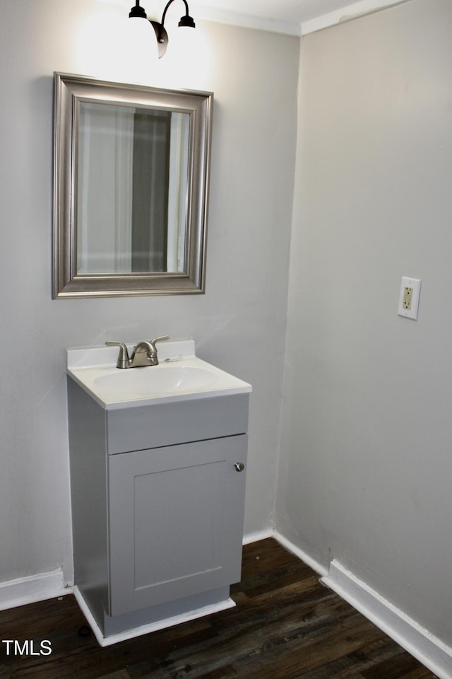 bathroom featuring ornamental molding, vanity, baseboards, and wood finished floors