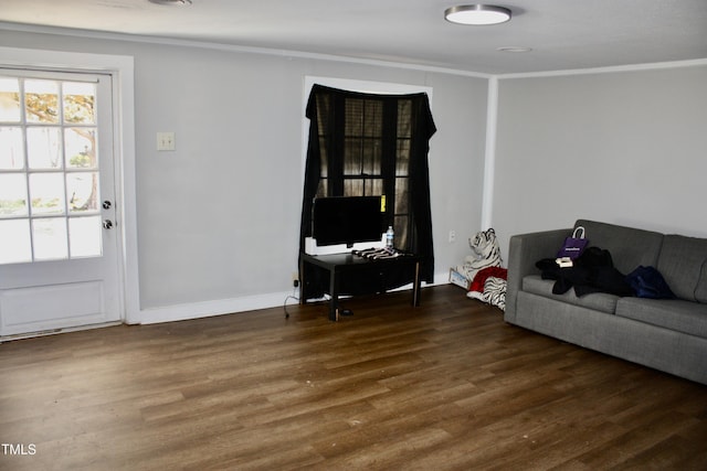 living area with crown molding, baseboards, and wood finished floors