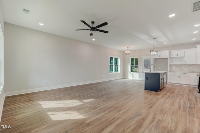 unfurnished living room with ceiling fan, light wood-style flooring, recessed lighting, a sink, and baseboards