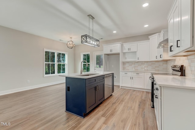 kitchen with appliances with stainless steel finishes, a sink, under cabinet range hood, white cabinetry, and backsplash