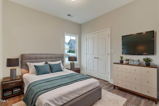 bedroom featuring visible vents, baseboards, and wood finished floors