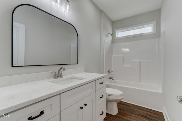 full bath with  shower combination, vanity, toilet, and wood finished floors