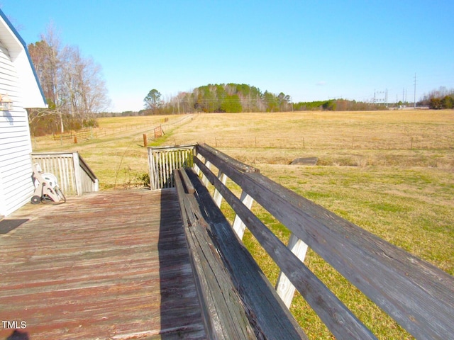 wooden deck featuring a rural view and a yard