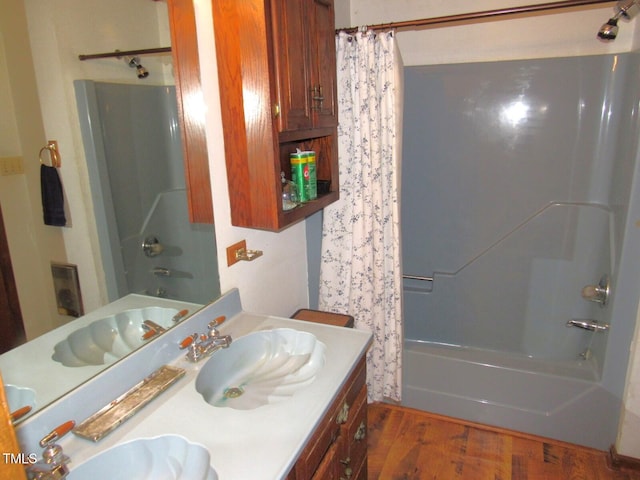 bathroom featuring shower / bathtub combination with curtain, vanity, and wood finished floors