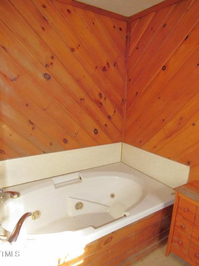 full bathroom featuring a whirlpool tub and wood walls