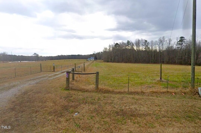 view of yard with fence and a rural view