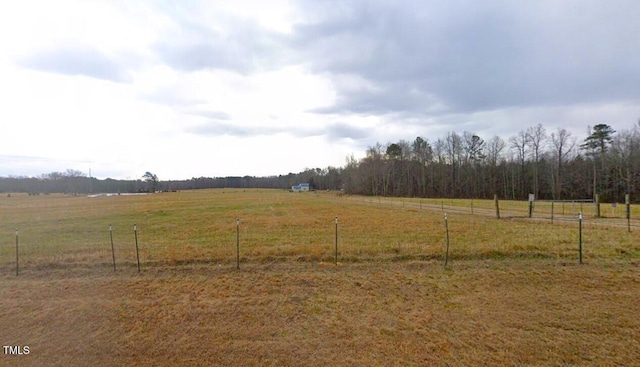 view of yard with a rural view and fence